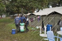 Members of the Ebola vaccination team based in the camp in Iboko move an Arktex container containing the vaccines out of their tent in preparation for a vaccination planned in the area later that day.