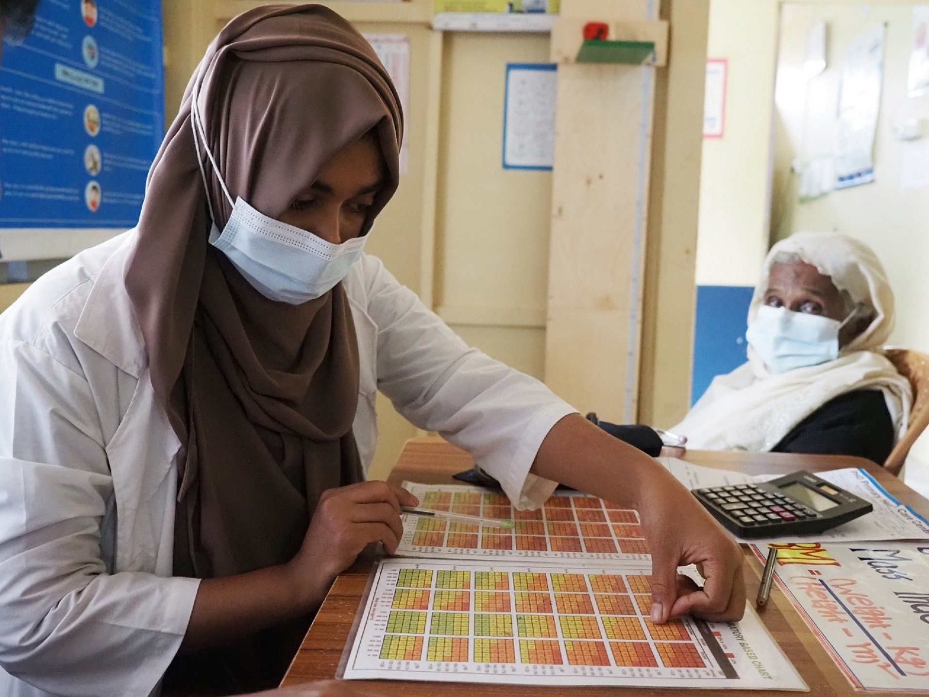 health worker sitting at desk with patient sitting